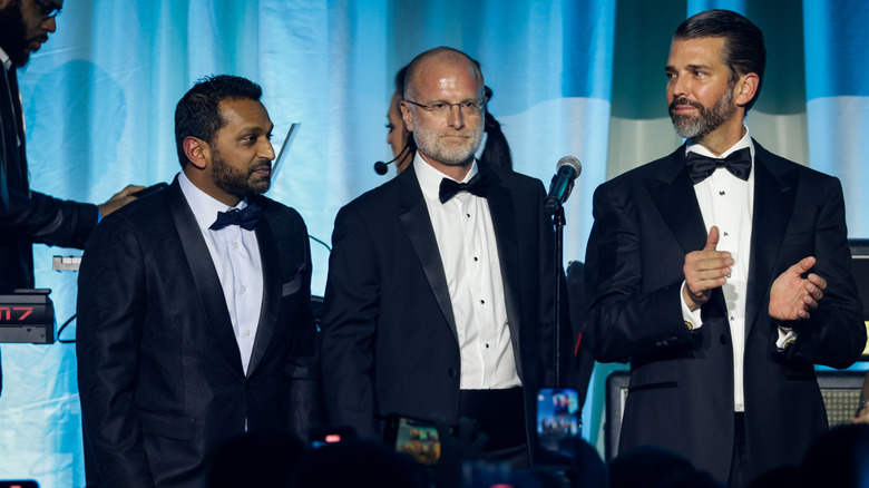 Brendan Carr (center) with Kash Patel and Donald Trump Jr. at a Turning Point USA event