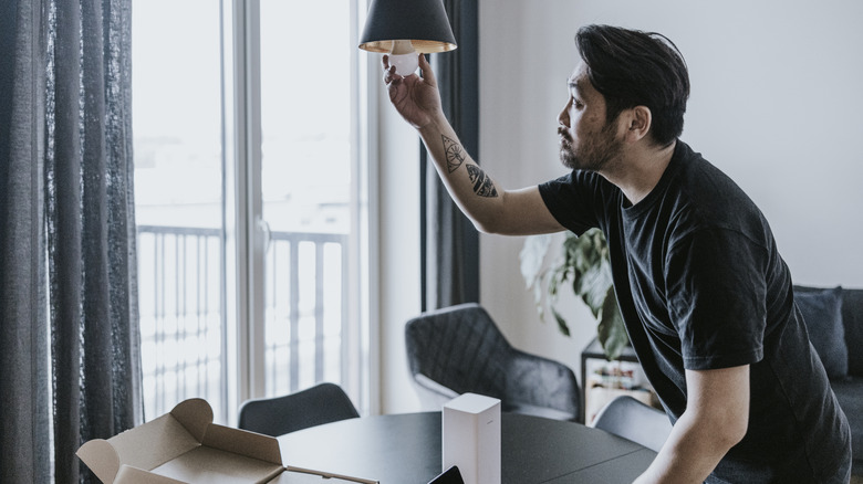 Person installing a smart light bulb.