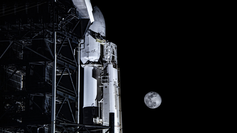 A SpaceX rocket with the moon in the background.