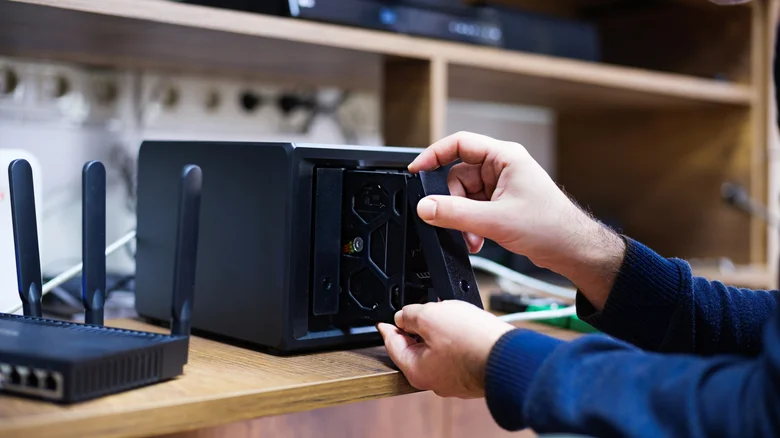 Person installing a hard drive into a NAS.