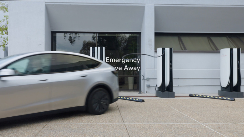 A Tesla vehicle driving away from the charger