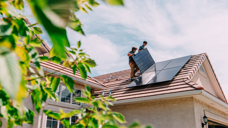 Fitters installing solar panels onto the roof of a home