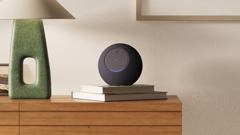 Amazon Studio with Home Camera shown sitting on two books on a dresser with a green lamp