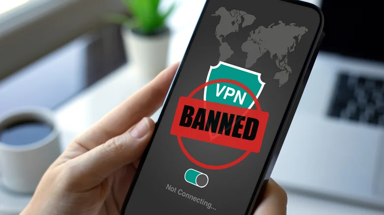 A person attempting to use a VPN on their phone with a red BANNED symbol across the screen.
