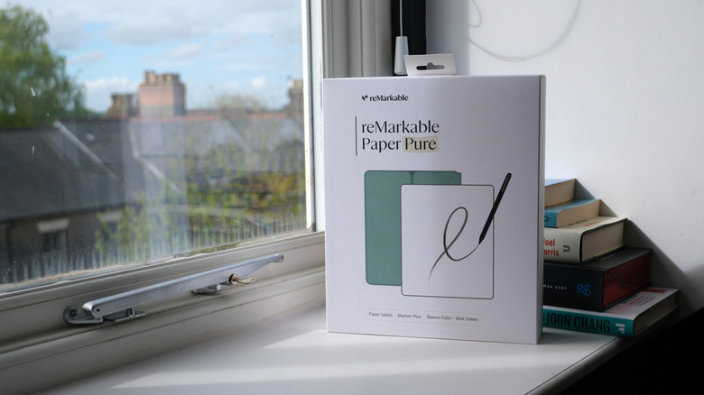 A boxed Remarkable Paper Pure e-paper tablet sits on a windowsill.