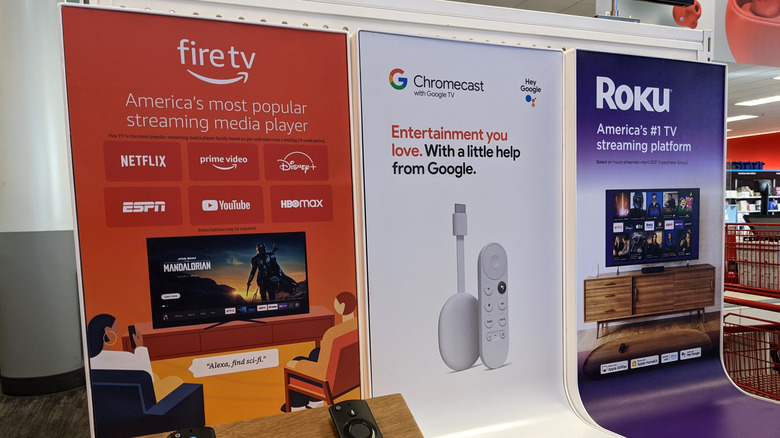 A display of popular streaming media players, including Fire TV, Chromecast, and Roku, in an electronics store