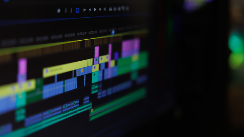 Close-up of a video editing timeline on a computer screen, showing multiple color-coded video and audio tracks.