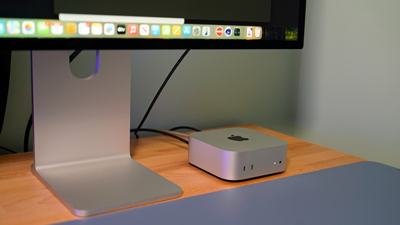 A Mac mini alongside a Mac Studio Display on a table.