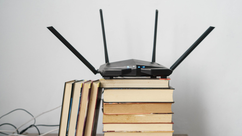 A Wi-Fi router on a stack of books.