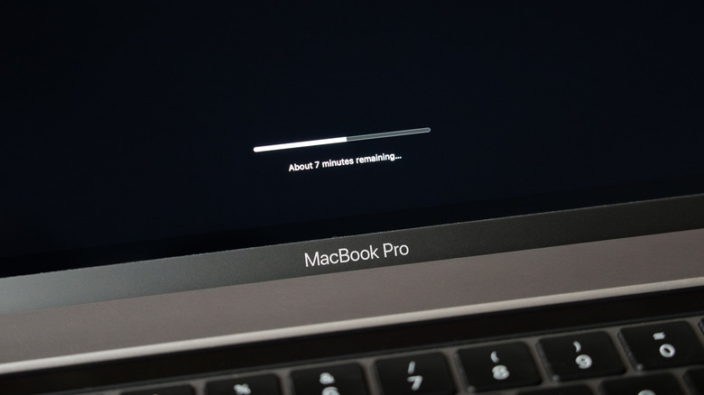 A MacBook Pro on the black software update loading screen.