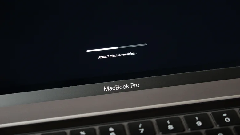 A MacBook Pro on the black software update loading screen.