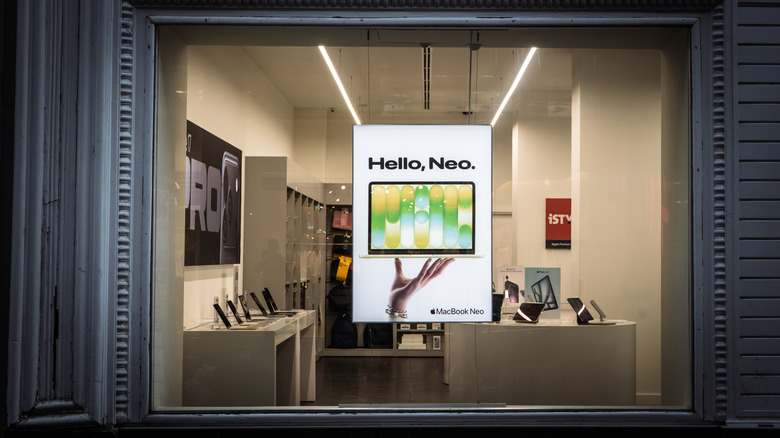 A MacBook Neo banner luring shoppers into a tech shop.