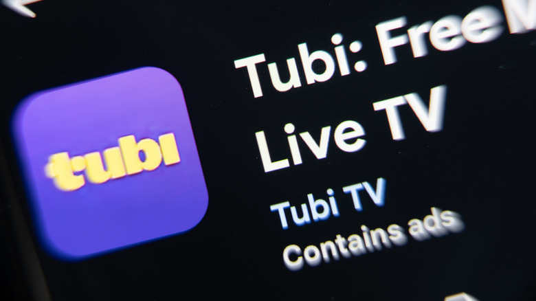 Close-up of the Tubi app on Google Play, showing its purple logo along with "Live TV" and "Contains ads."