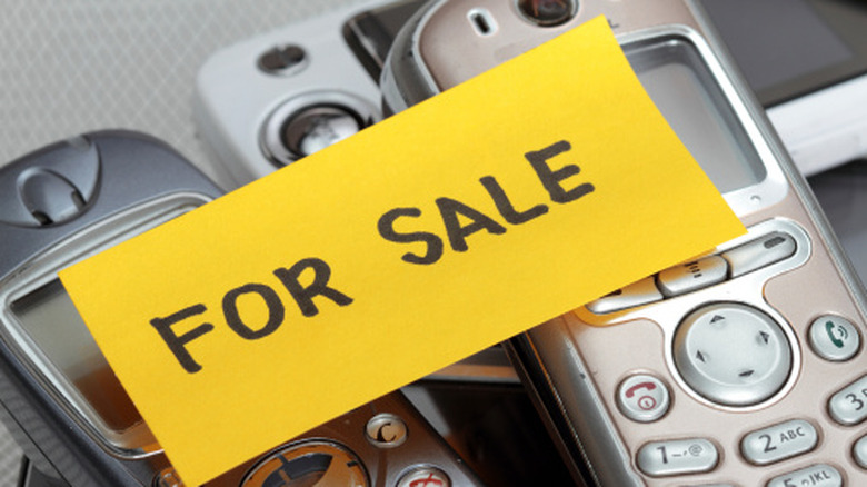 Old cell phones with a "for sale" sticky note