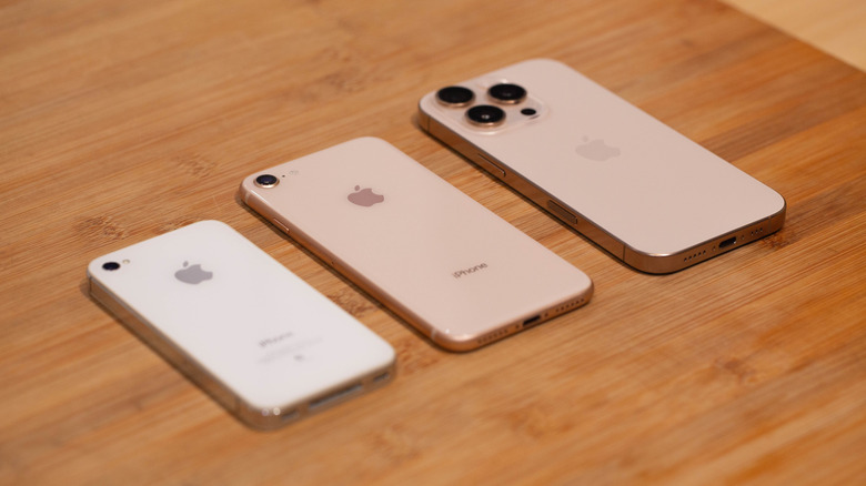 An iPhone 4S, 8, and 16 Pro face-down on a table