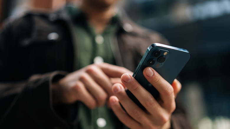 A person holding a blue iPhone.