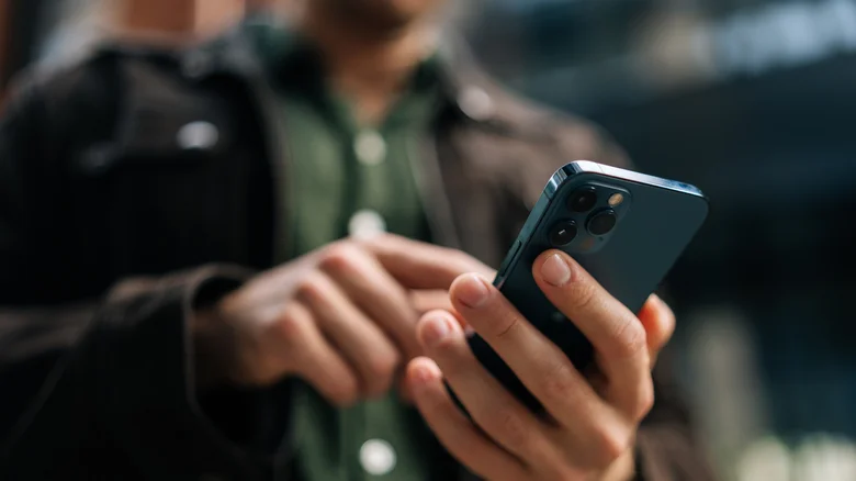 A person holding a blue iPhone.
