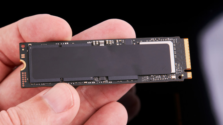Person holding an M.2 NAND SSD storage drive.