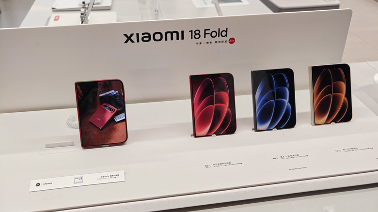 The Xiaomi 18 Fold, shown in various colors on a store display table.