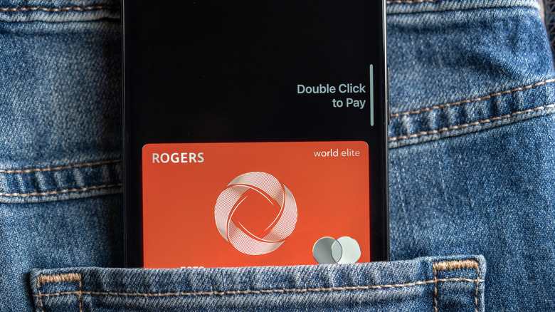 A credit card in someone's back pocket next to an iPhone.