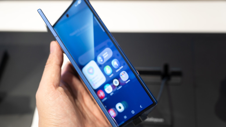 A partially-open, blue Samsung ZFold held in a hand.