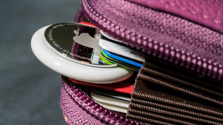 An Apple AirTag wedged between cards in a wallet.