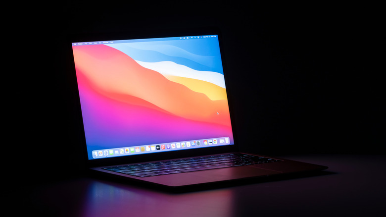 MacBook Air M1 model on a desk in a dark room