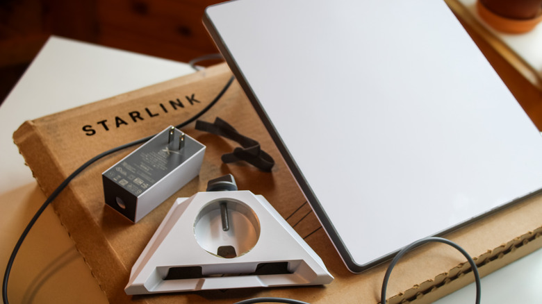 The components from a Starlink Mini kit, including dish, stand, and power connector.