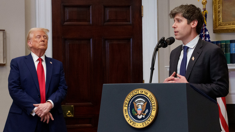 Sam Altman at the podium with President Trump in the back.