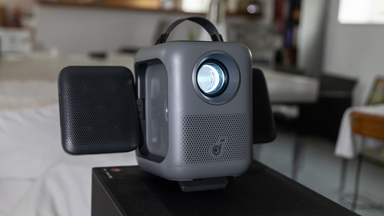 Anker's Nebula P1i portable projector is shown with the speakers extended.