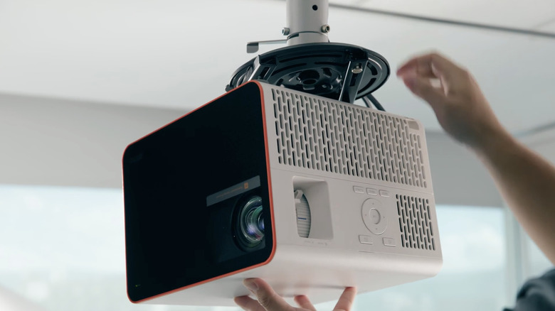 A BenQ X3100i gaming projector is shown being mounted to the ceiling