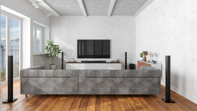 Large room with multiple speakers and a smart TV mounted on the wall.
