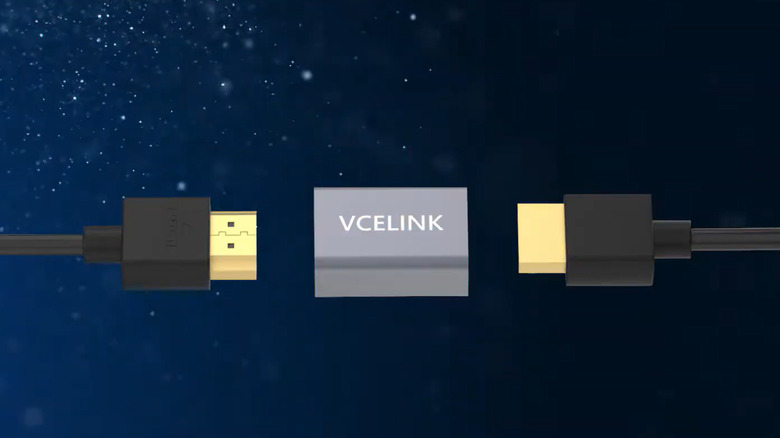 Two HDMI cables connect to a VCELINK HDMI coupler against a starry blue background.