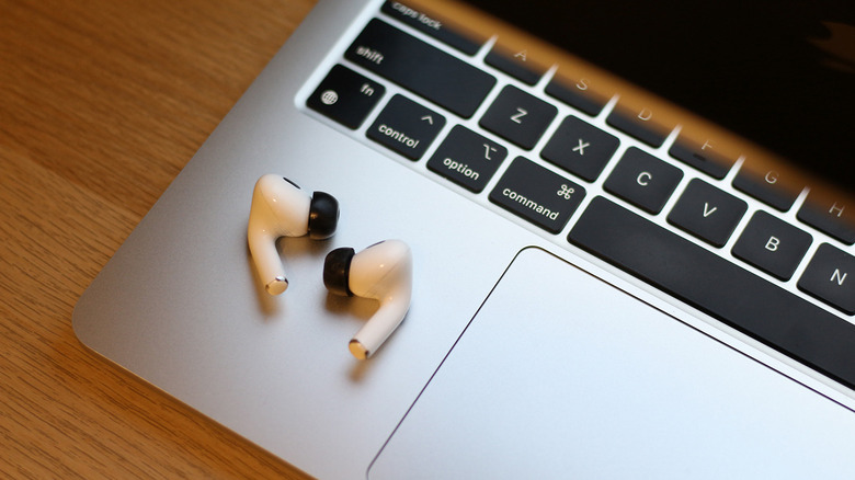 A pair of AirPods with memory foam ear tips installed.
