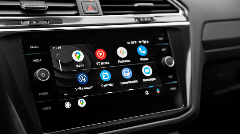 Android Auto home screen displayed on a car's infotainment system, with apps including Maps, YouTube Music, Podcasts, Phone and Messages.