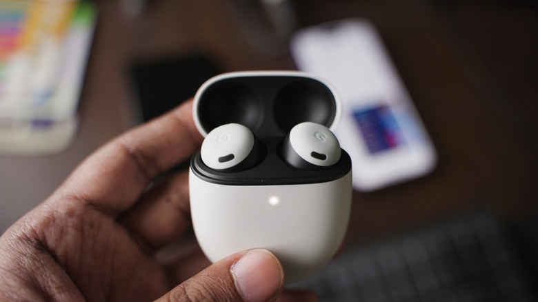 Pixel buds with the Google Pixel in the background.