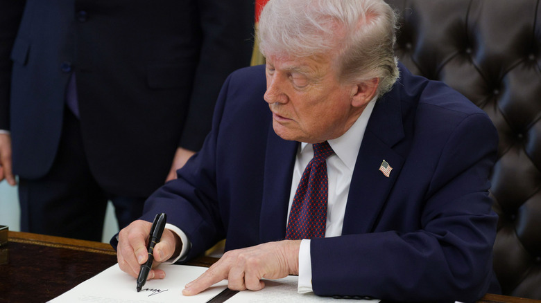 President Trump signs an executive order at the oval office.