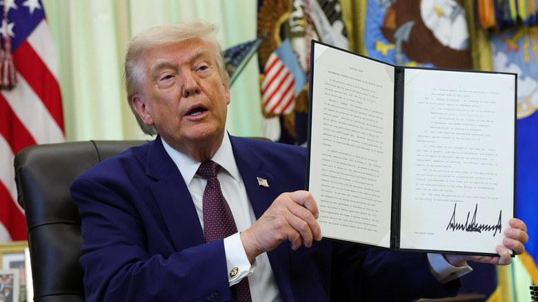 Trump showing off his signature on an executive order.