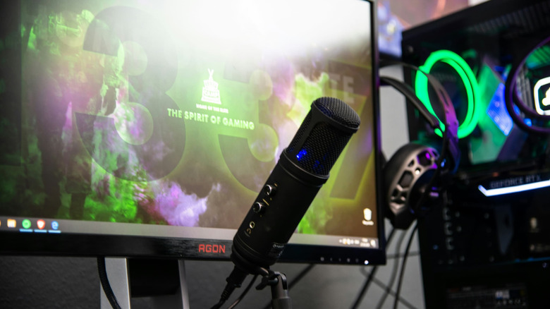 A livestreamer's setup with a computer, headphones and microphone