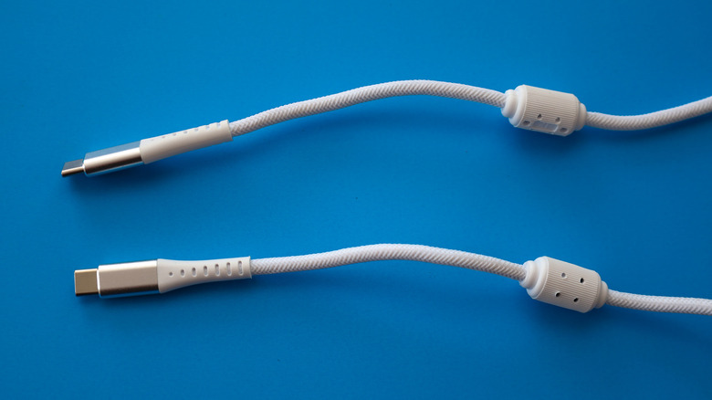 Two white USB cables on a blue surface.