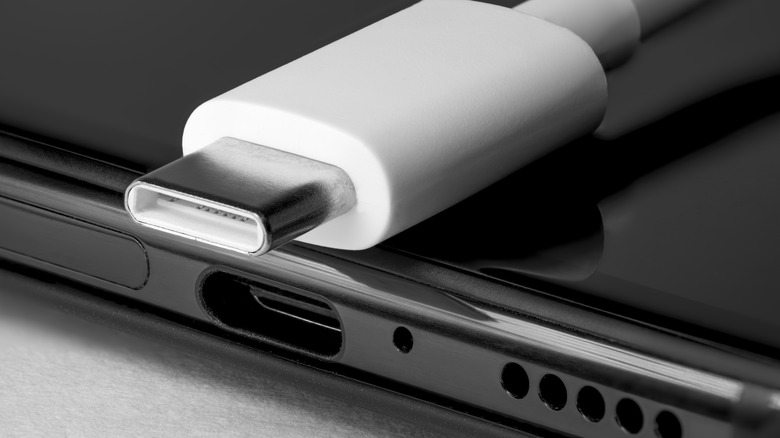 A USB4 cable next to a laptop.