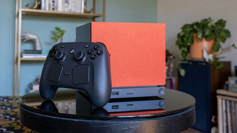 A Steam Machine in orange and black is shown with its controller