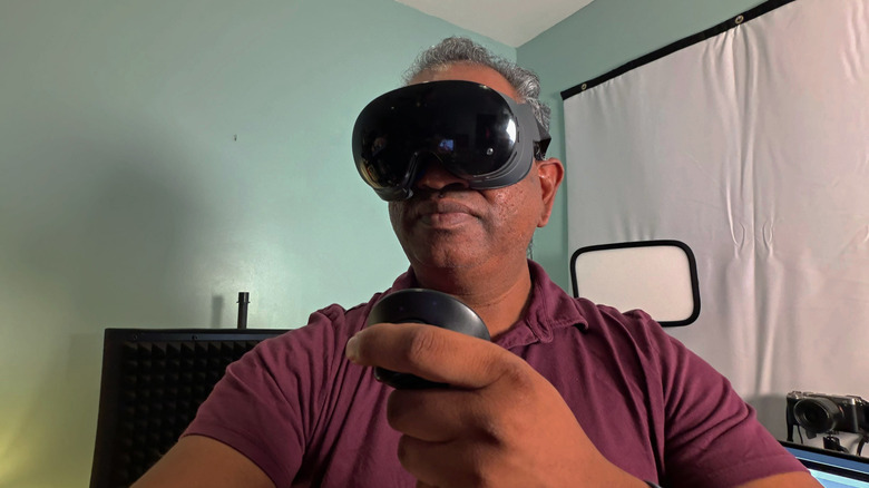 A man wearing the Steam Frame and holding one controller.