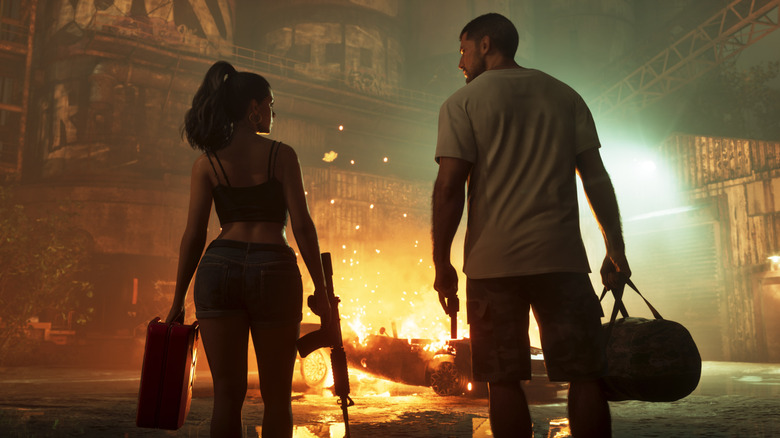 Jason and Lucia, holding cases and weapons, look at each other before a burning car in a dark warehouse.