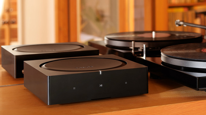 A Sonos amp next to a turntable spinning vinyl.
