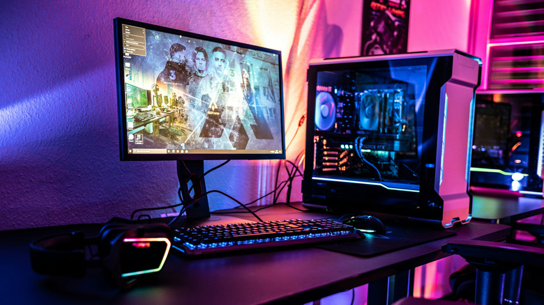 A desktop gaming PC setup, with dramatic (mostly purple) RGB lighting
