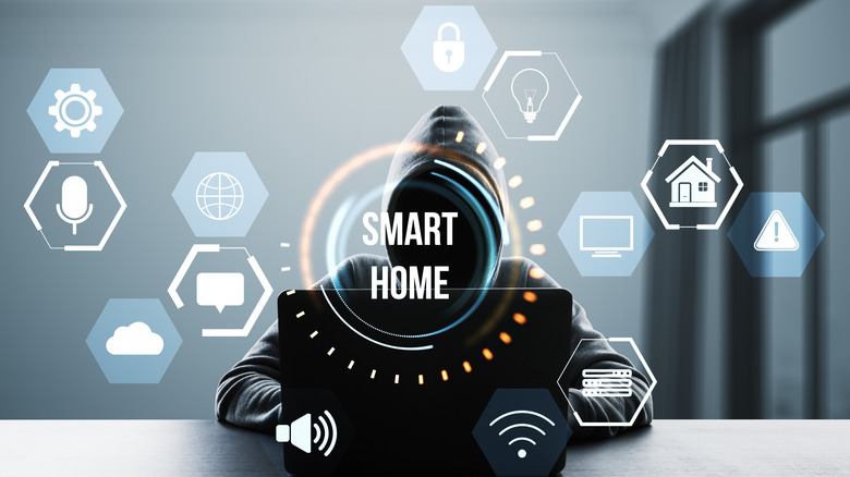 A hooded person with a laptop types as smart home symbols hover around the room