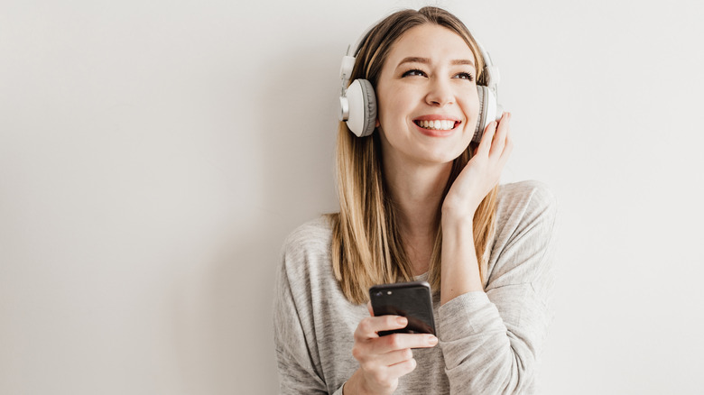 A woman listening to music in Bluetooth headphones and smiling