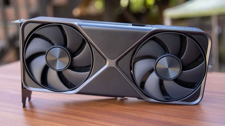 A RTX 5080 Founder's Edition sits on a wooden desk.