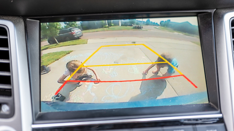 Children seen in a backup camera view from a vehicle